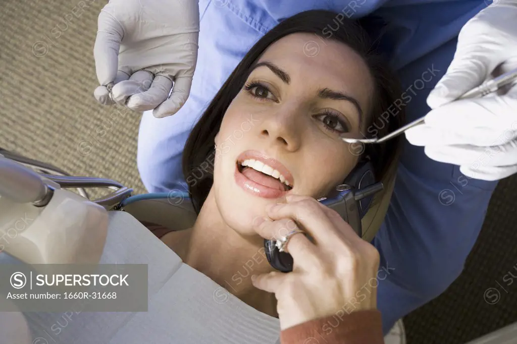 Woman with dental hygienist talking on cell phone
