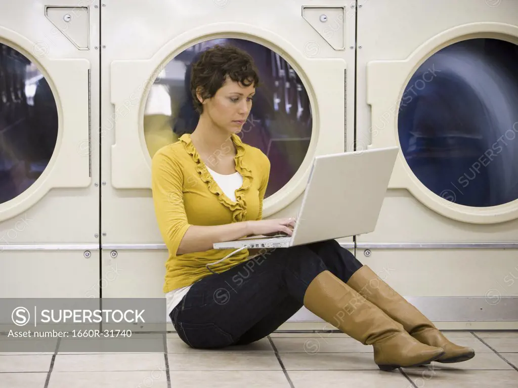 Woman sitting at Laundromat with books writing