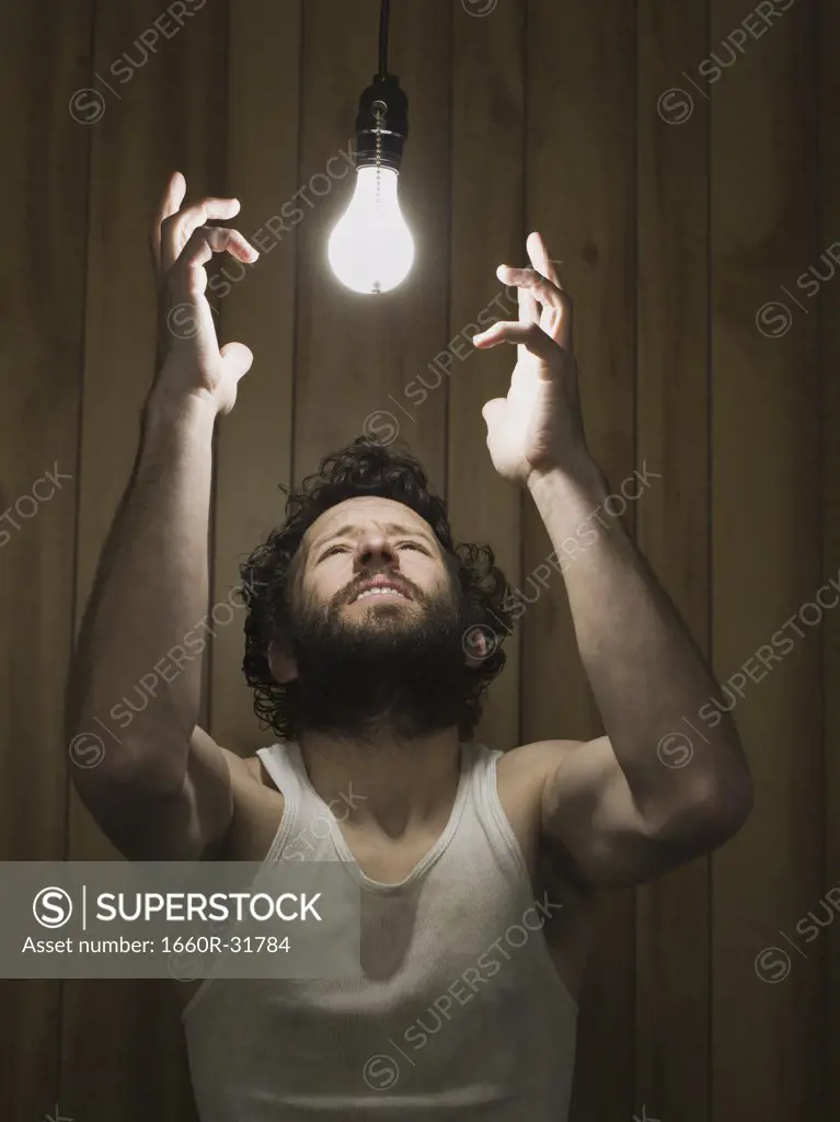 Man reaching up to light bulb