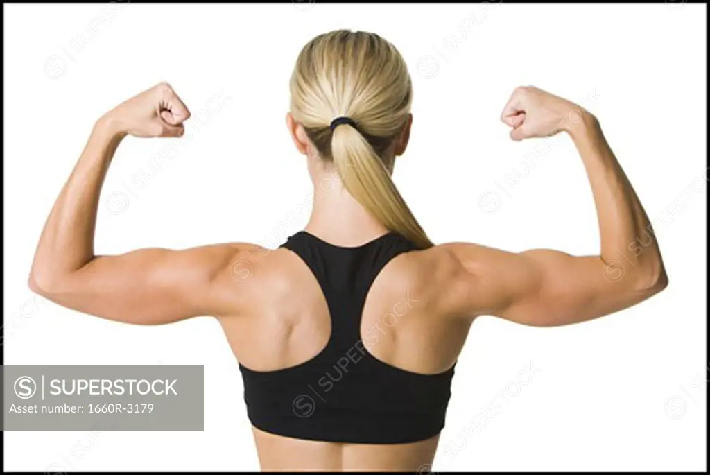 Rear view of a young woman flexing her muscles