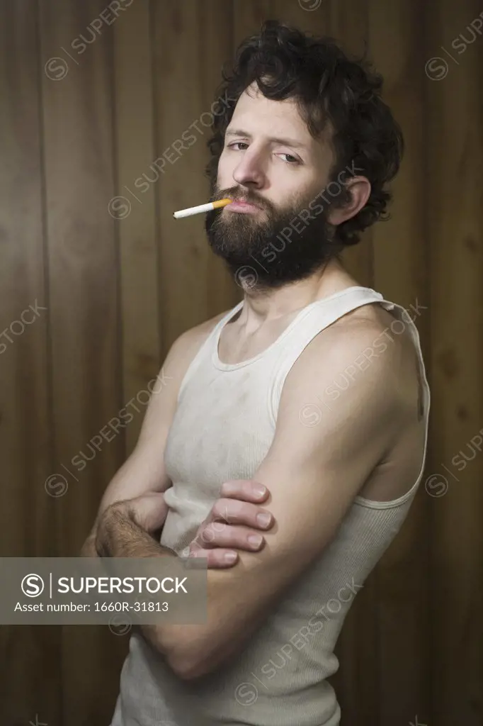Man standing with cigarette and crossed arms
