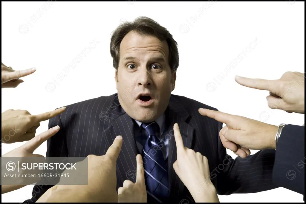 Businessman with fingers pointing at him