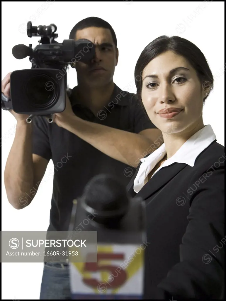 Female journalist with microphone and male videographer