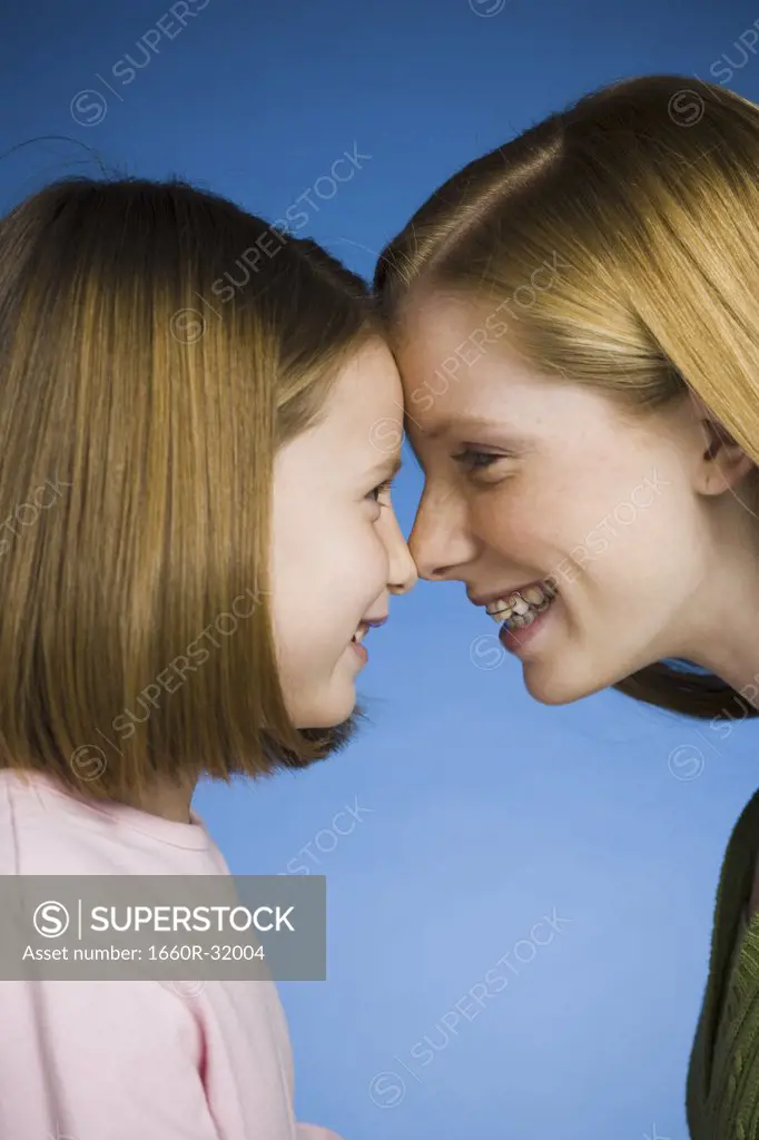 Two girls face to face smiling