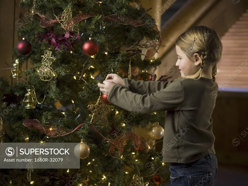 Girl with Christmas bauble and Christmas tree