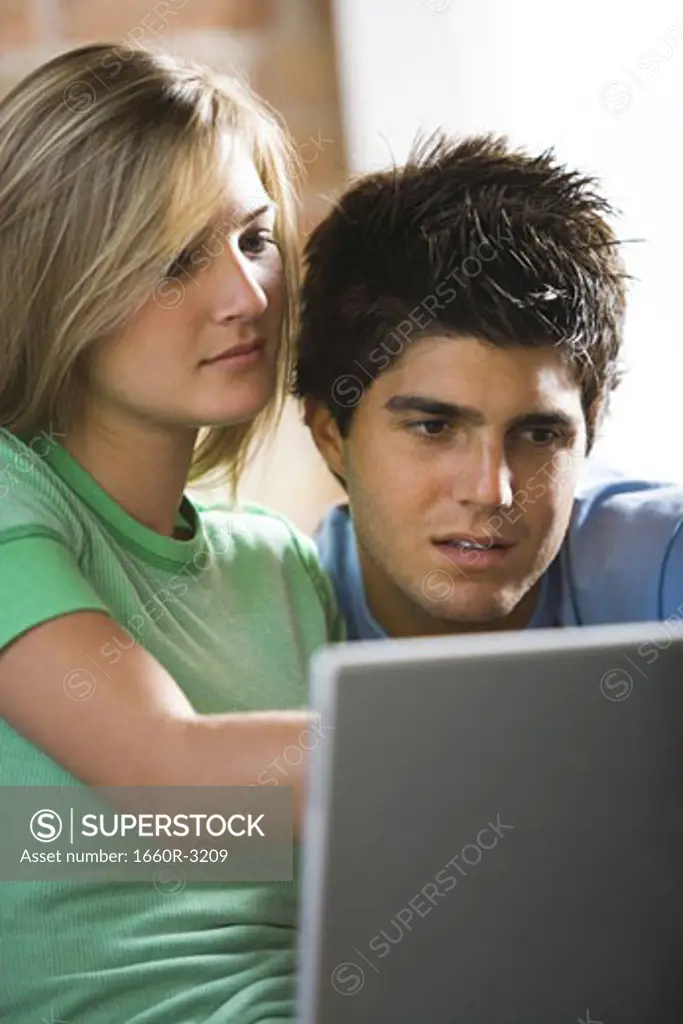 Close-up of a young couple looking at a laptop