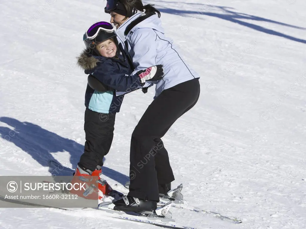 Woman and young girl skiing