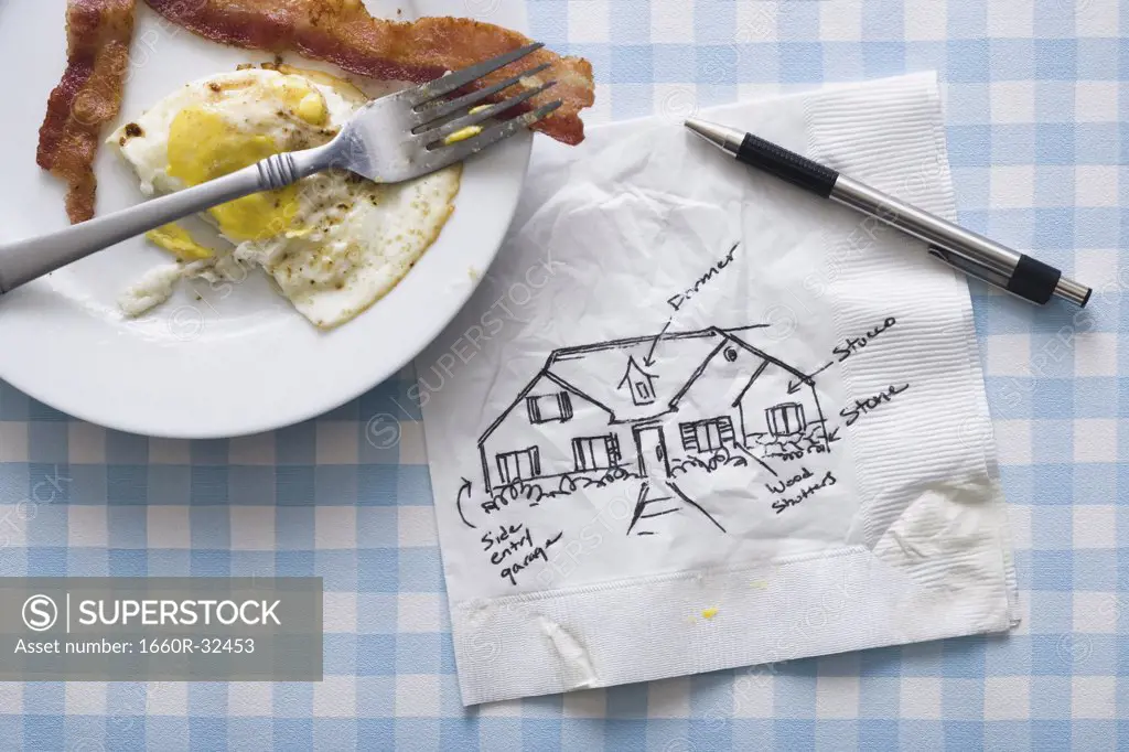 Bacon and eggs with fork and napkin with pen and sketch of house