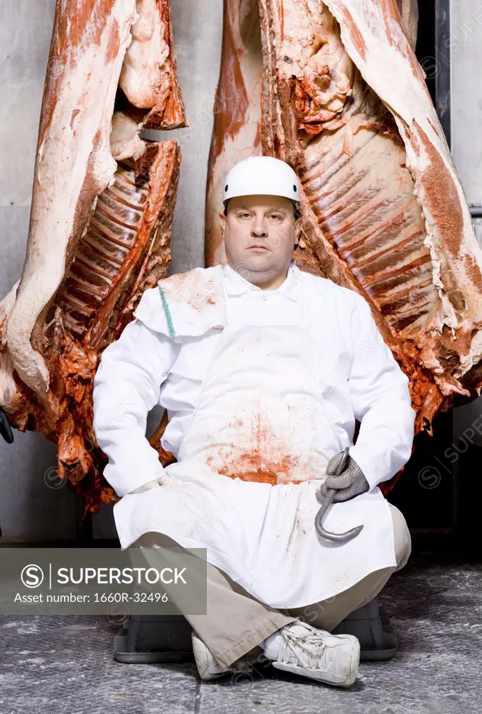 Butcher sitting with carcass and meat hook