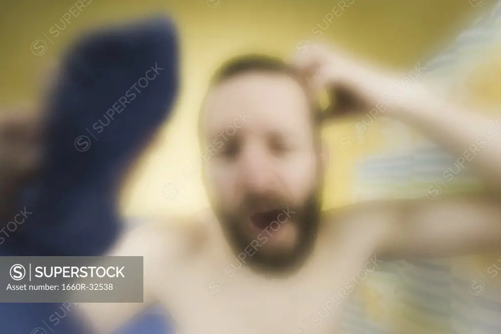 Man in bathroom scratching head and yawning