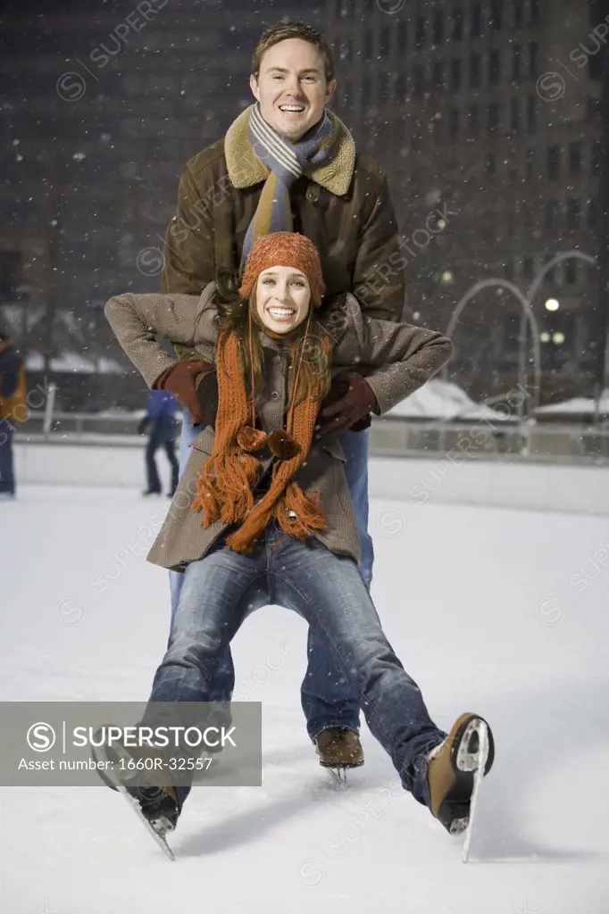Couple falling while ice skating