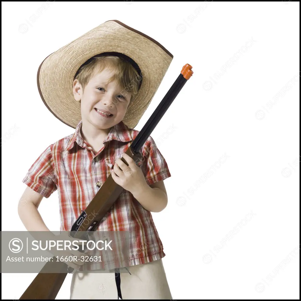 Boy with toy rifle and cowboy hat