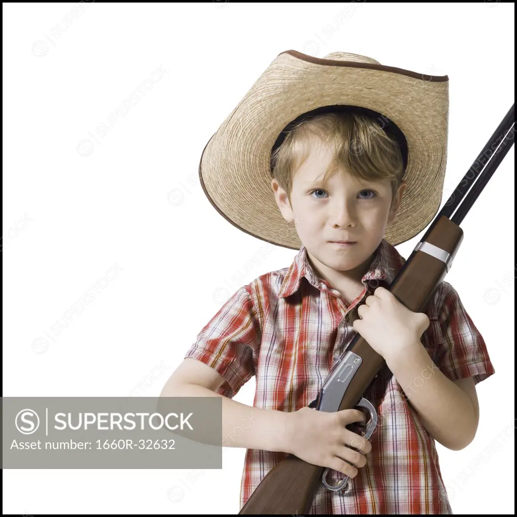 Boy with toy rifle and cowboy hat