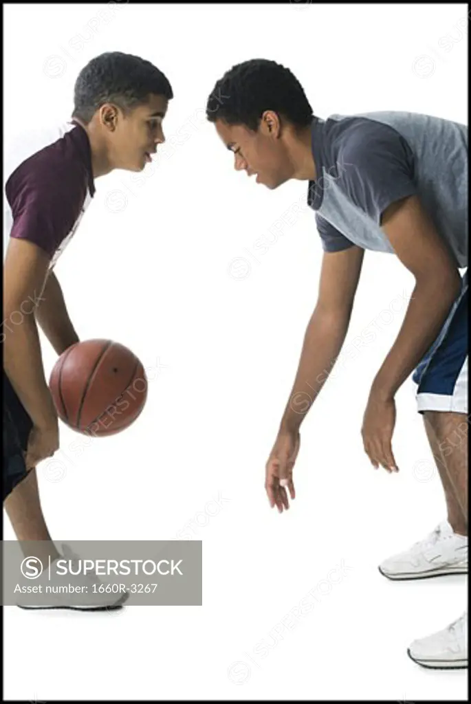 Profile of two young men playing basketball