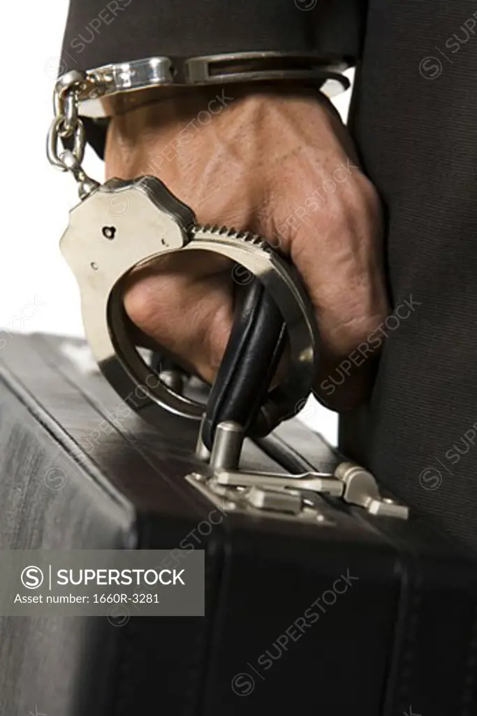 Businessman handcuffed to a briefcase