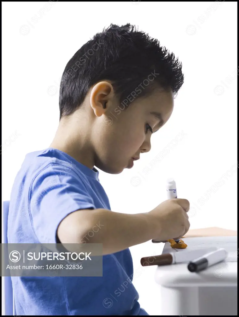 Boy sitting at table doing crafts