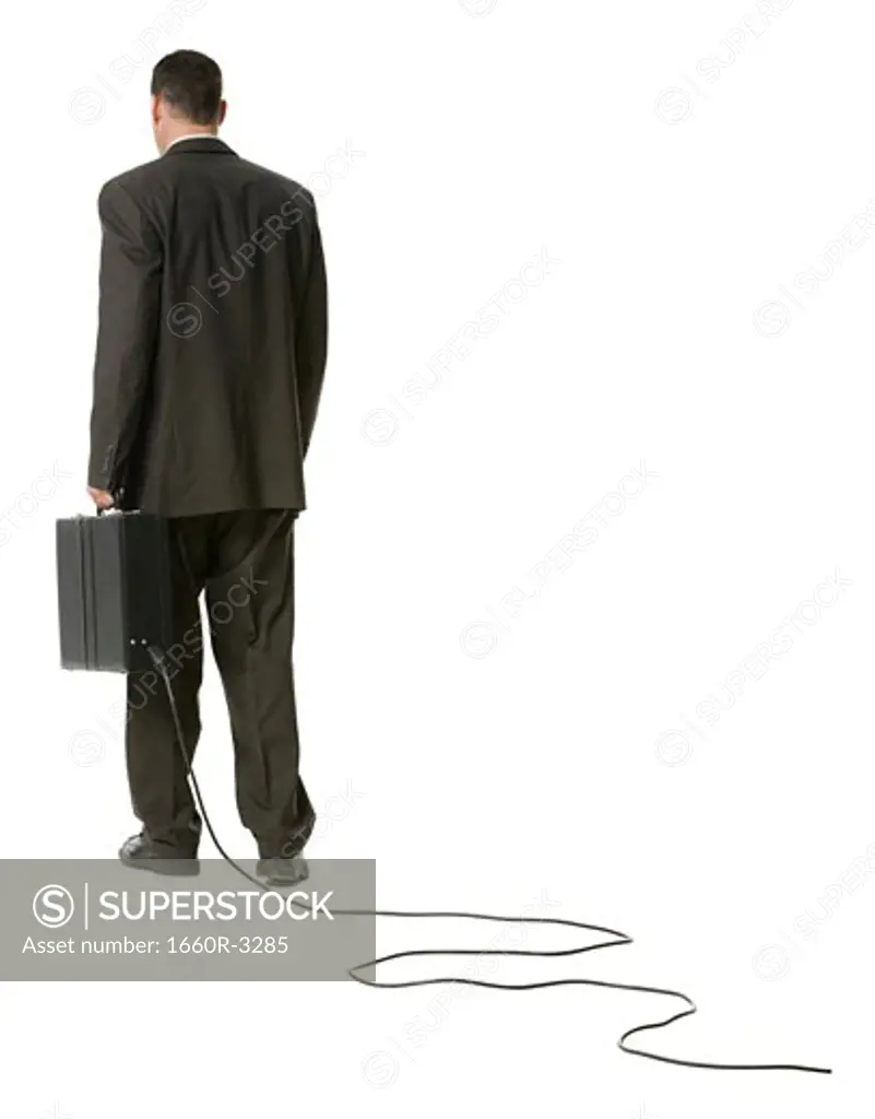 Rear view of a businessman holding a briefcase with an electrical cord