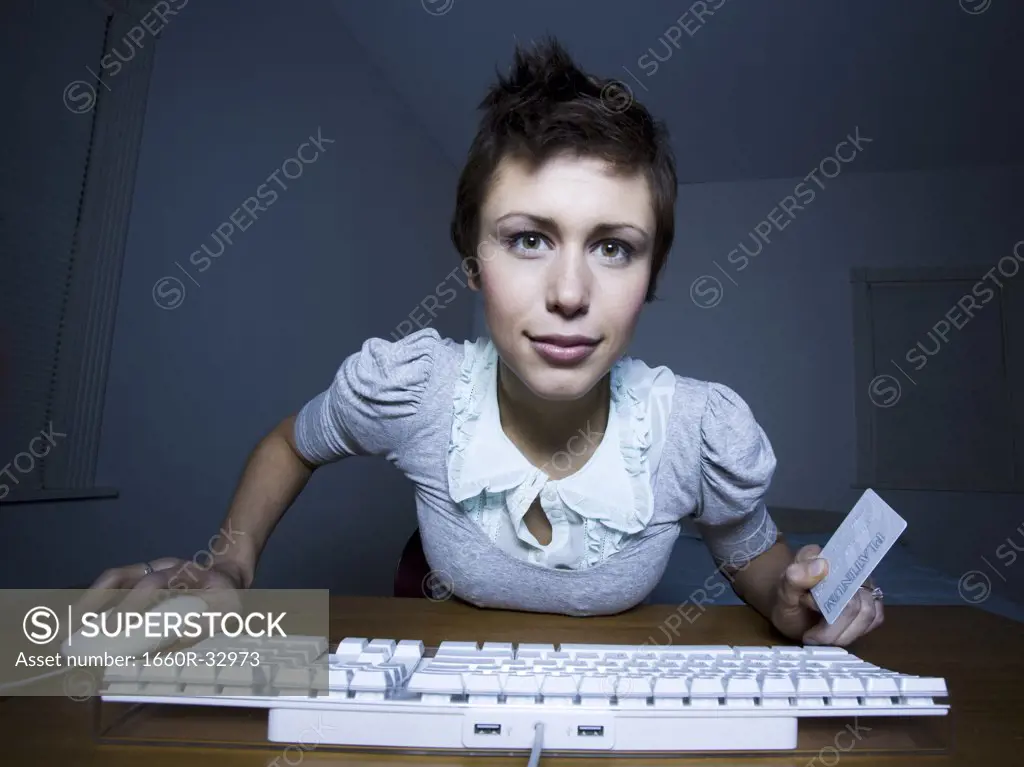 Woman sitting at keyboard with credit card