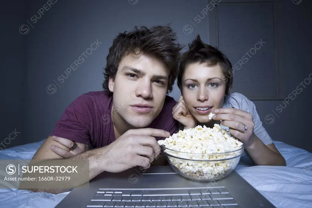 Couple eating popcorn and smiling