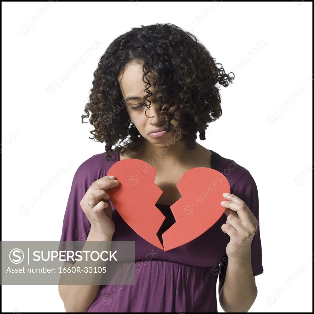Woman holding broken red heart
