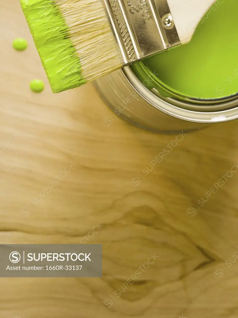 Detailed view of green paint with brush on can and paint chips