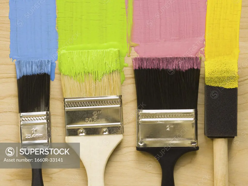 Four paint brushes with stripes of paint