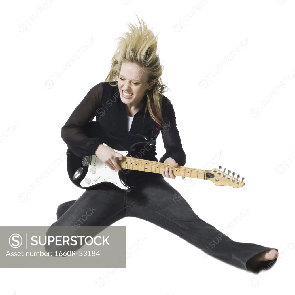 Woman jumping with electric guitar