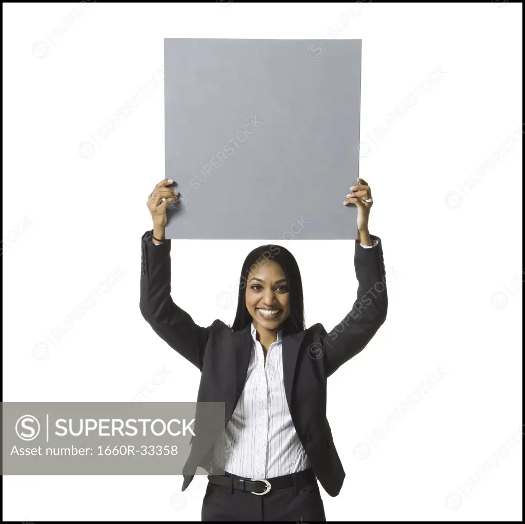 Businesswoman standing with blank sign over head
