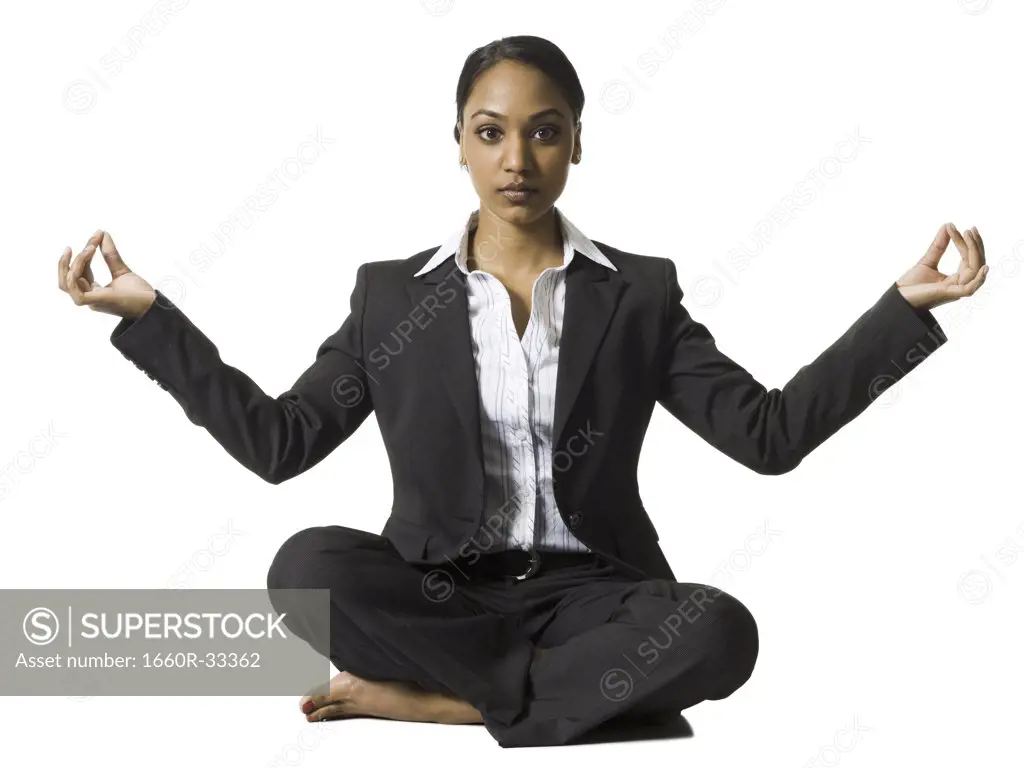 Businesswoman sitting cross legged doing yoga