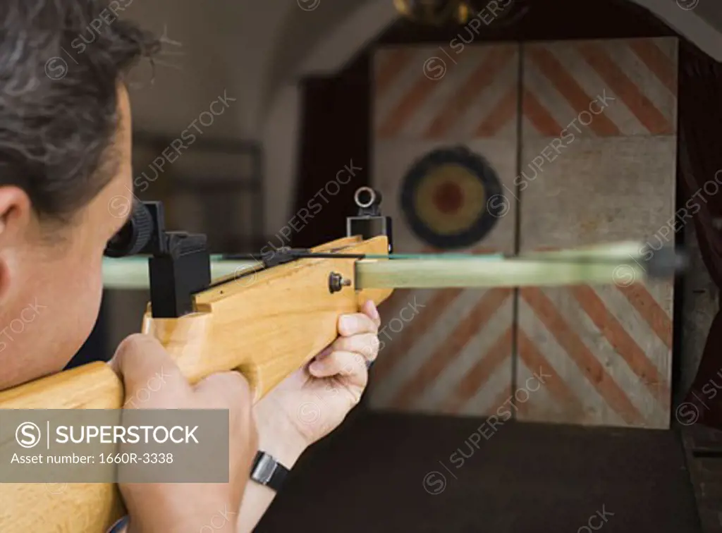 Close-up of a young man aiming at a target