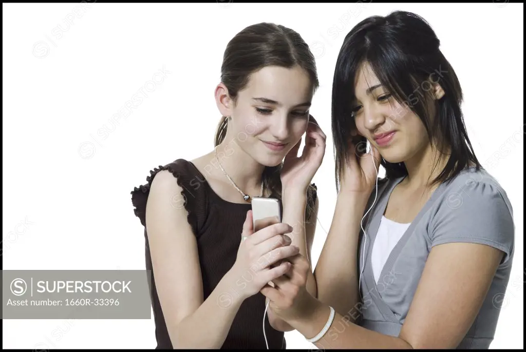 Two girls listening to mp3 player smiling