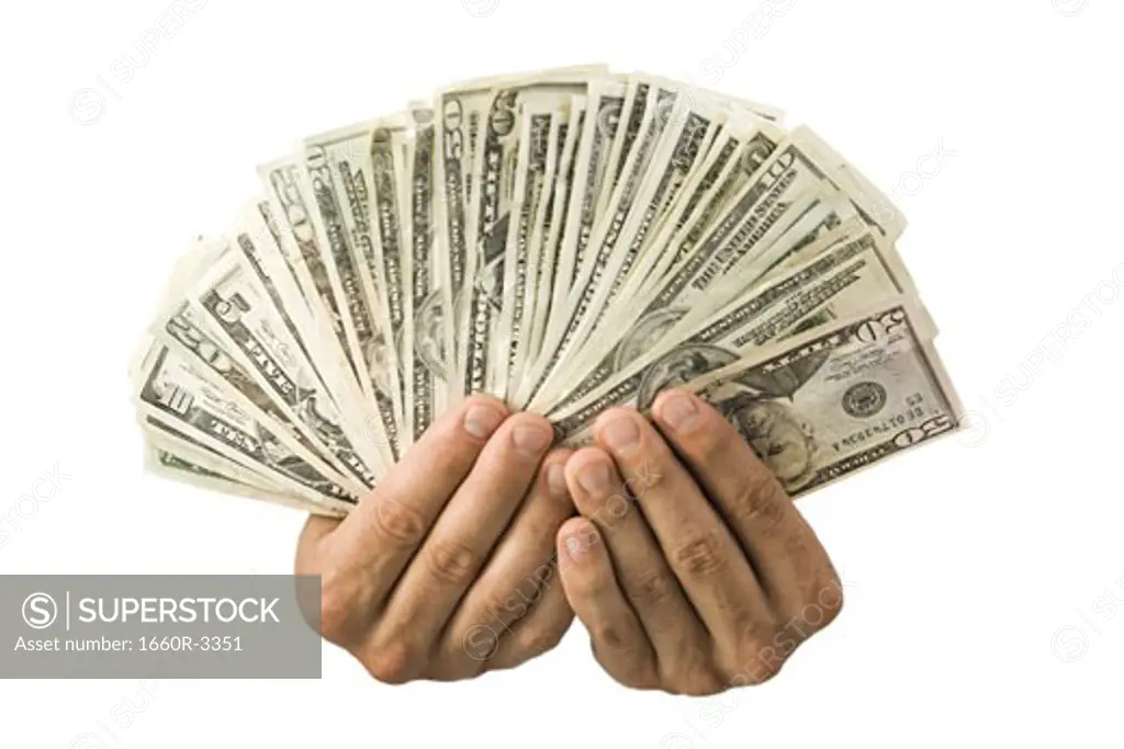 Close-up of hands fanning out paper currency