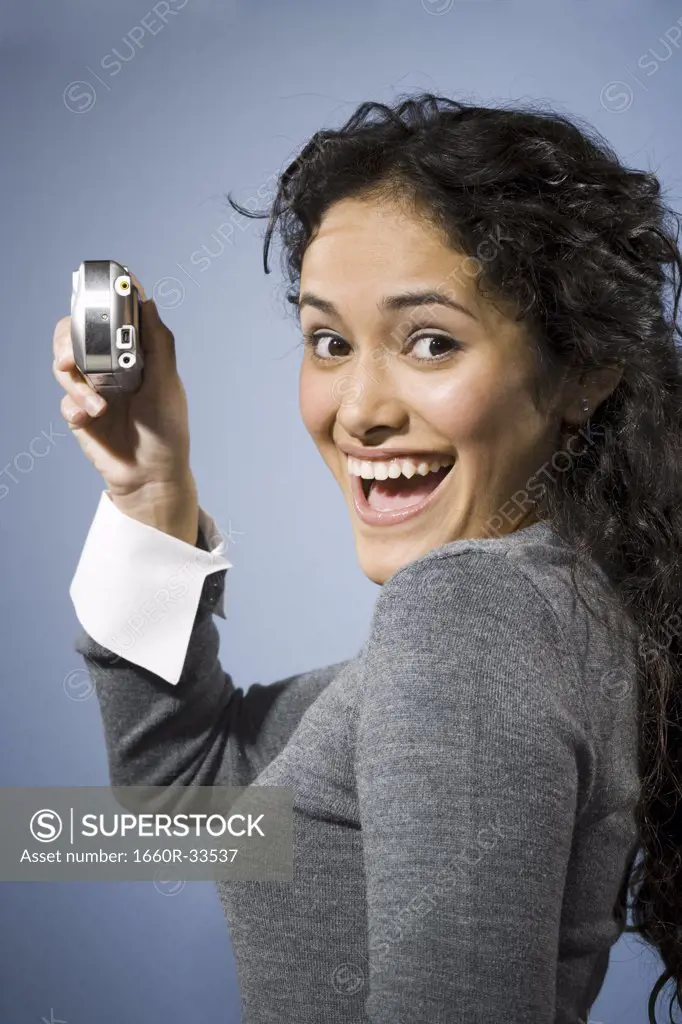 Woman taking a photo with digital camera smiling