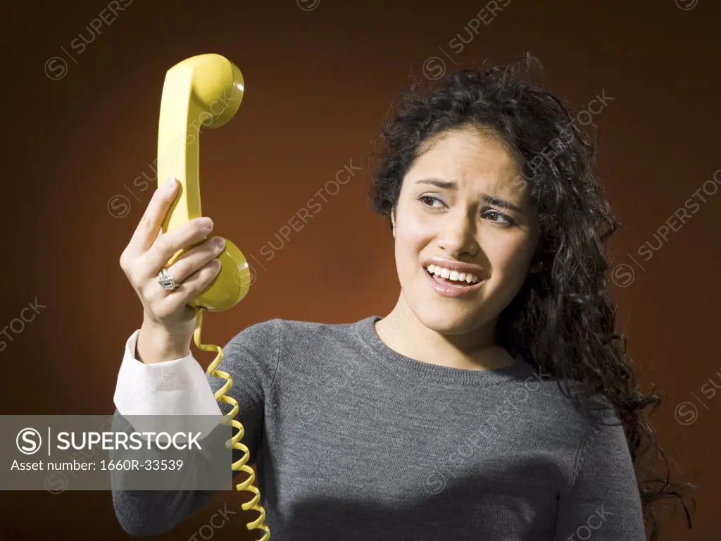 Woman holding retro phone and yelling