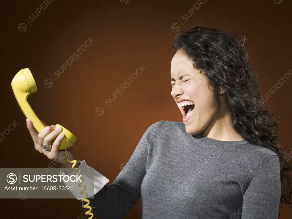 Woman holding retro phone and yelling