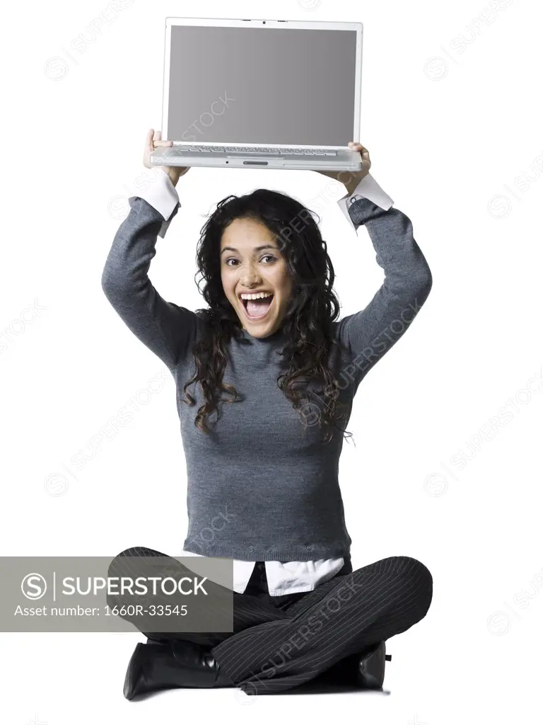 Woman sitting cross legged with laptop smiling