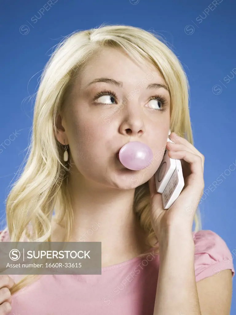 Girl talking on cell phone and blowing bubble