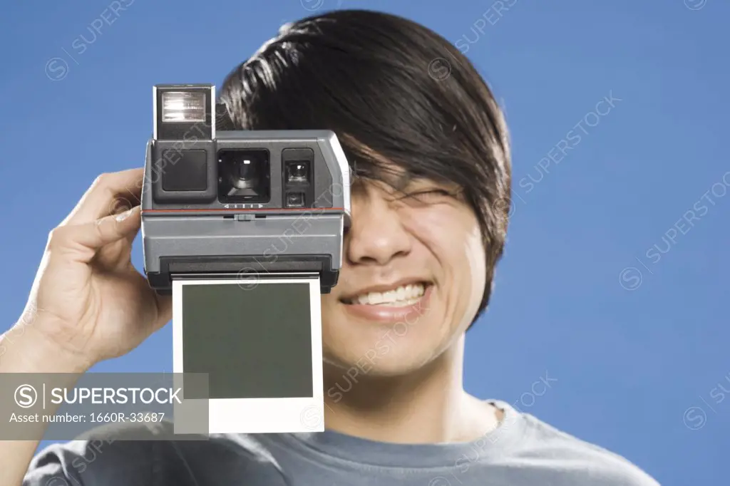 Man with instant camera and blank photo