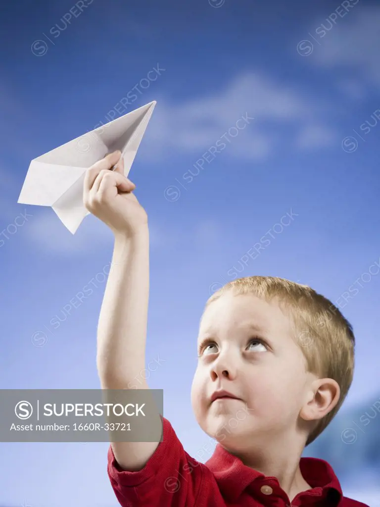 Boy with paper airplane outdoors