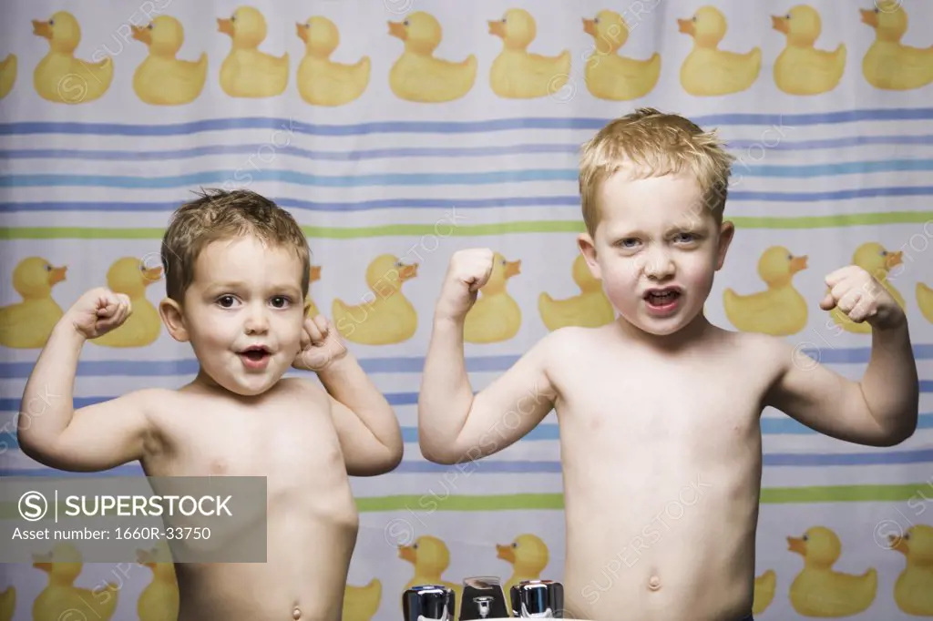 Two boys flexing muscles in bathroom