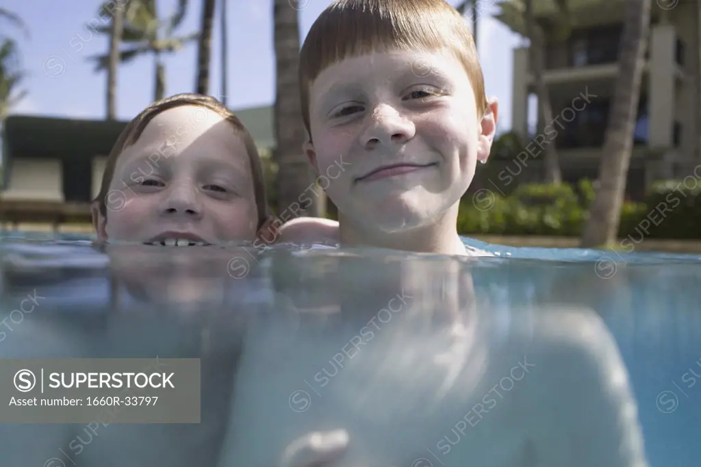 Two boys in outdoor pool smiling