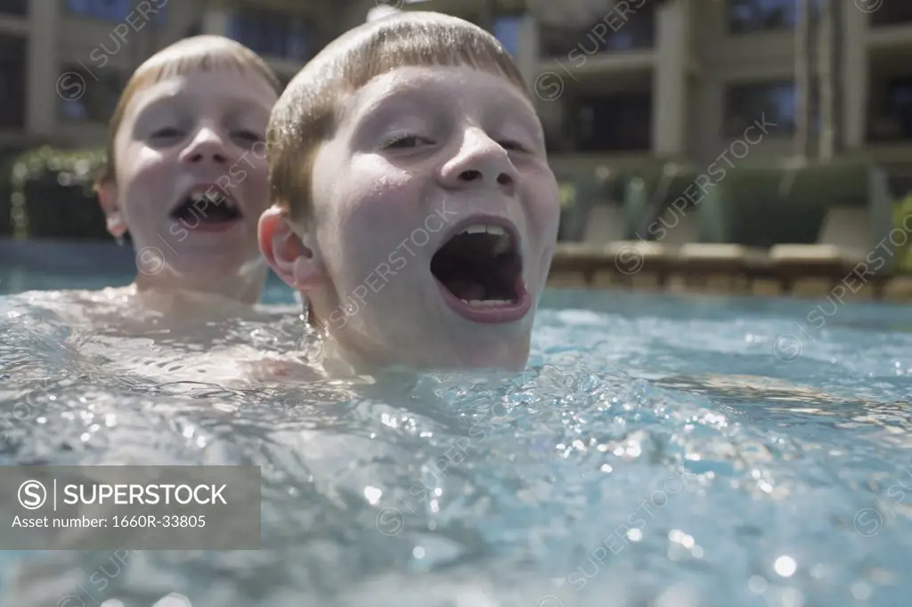 Boy in outdoor pool making funny face