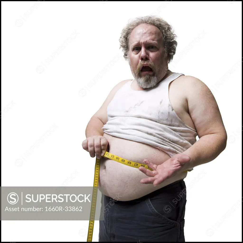 Obese man measuring waist with tape measure