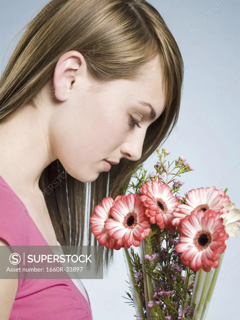 Profile of woman smelling flowers