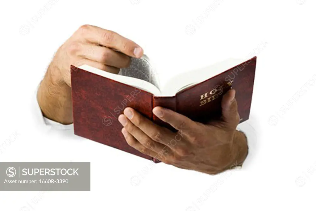 Close-up of hands turning the pages of the Bible