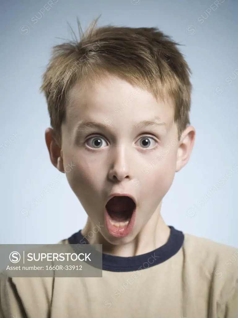 Boy with hands on face and mouth open surprised