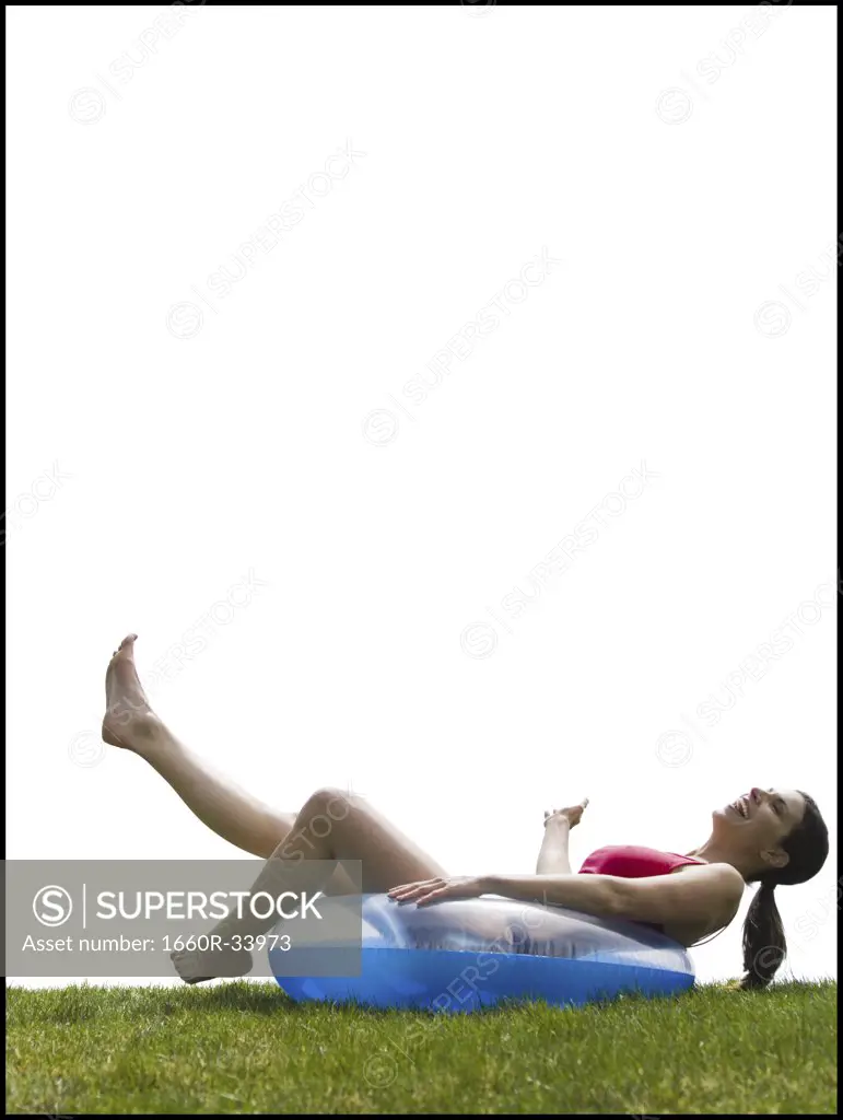 Woman in bikini lying in swimming ring laughing