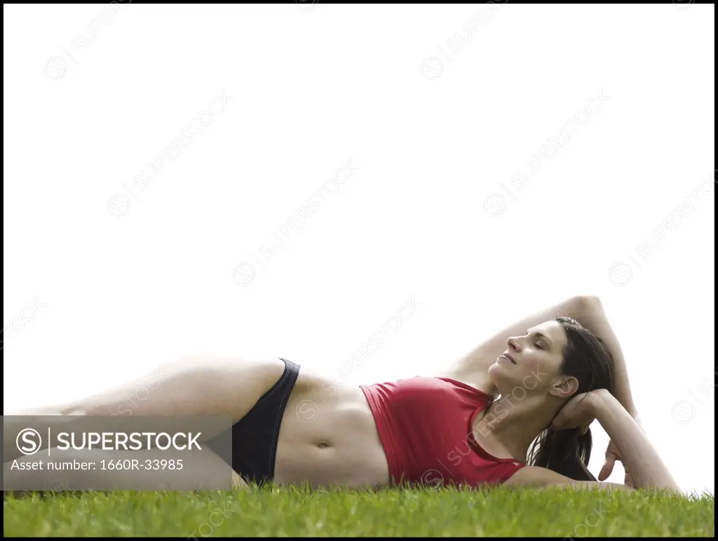 Woman in bikini lying down in grass
