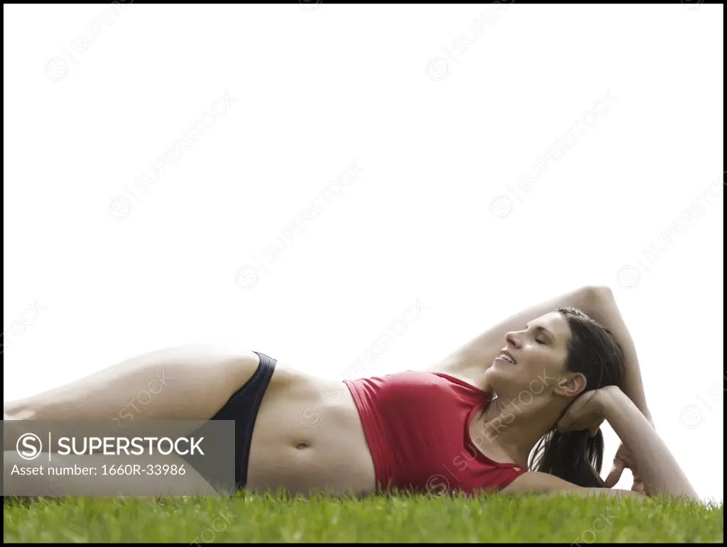 Woman in bikini lying down in grass