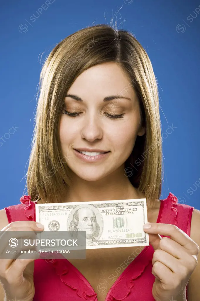 Woman holding American hundred dollar bill